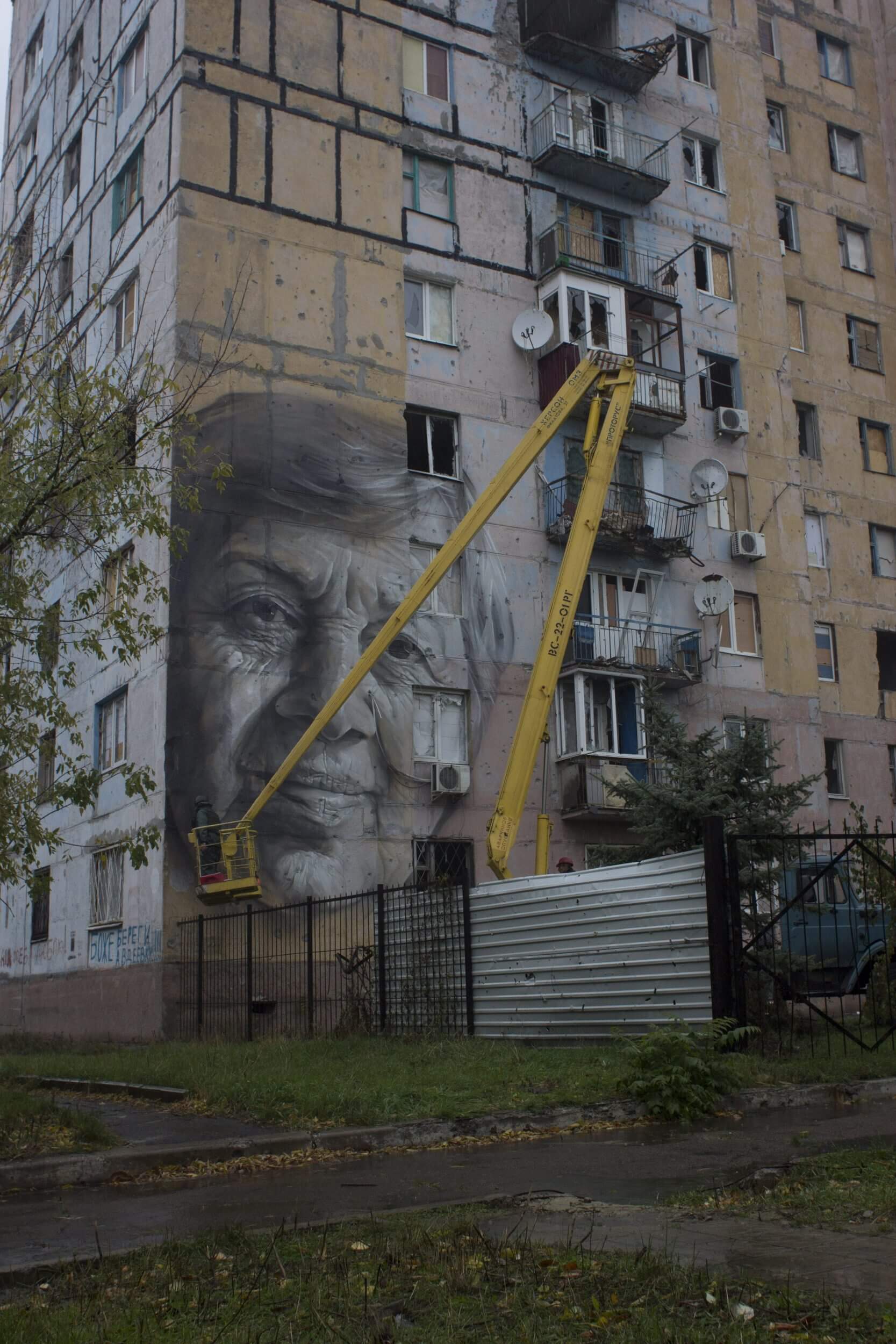 Street Artist Guido Van Helten paints on the Frontline, Avdiyivka ...